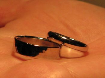 Finished, polished rings. His has a slight hammered finish, hers is a traditional plain band
